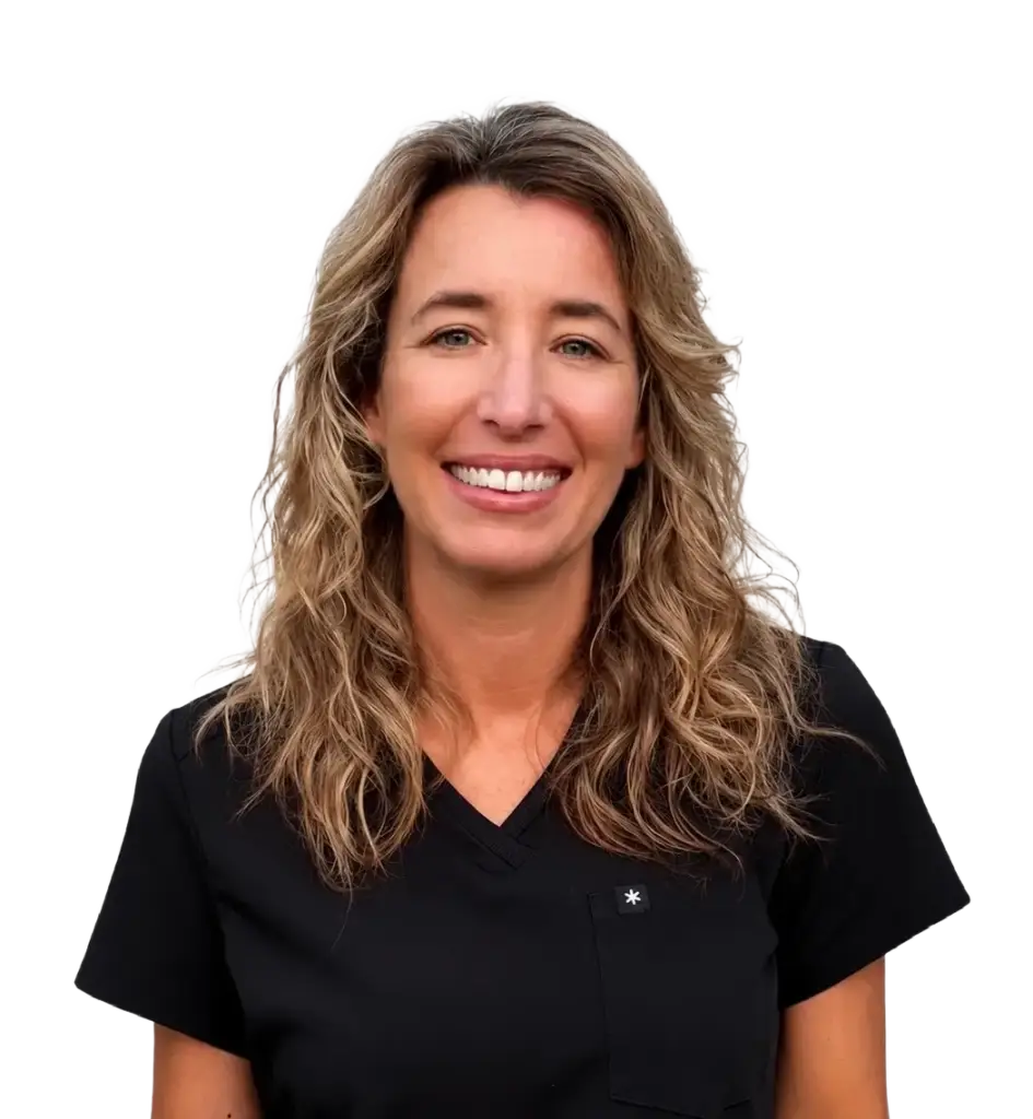 Smiling woman with wavy blonde hair wearing black scrubs against a white background.